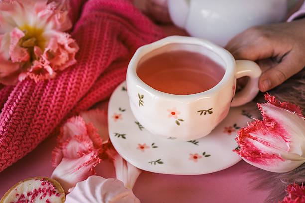 istock Cozy flat lay with pink tea in a floral cup, tulips, candlelight, sweets, and soft textures on a pink background. Feminine Valentine's or romantic morning mood 2209677514