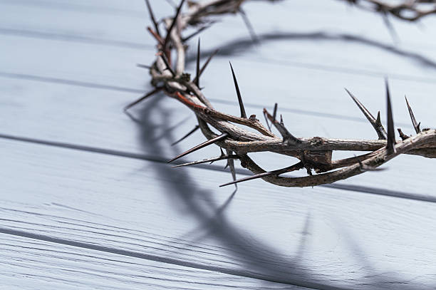 istock Wooden wall casting dark shadow from Jesus crown of thorns, symbolizing religious suffering and sacrifice Christian background, Easter concept Banner 2209679029