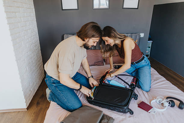 istock Happy young couple packing for a trip 2209683413