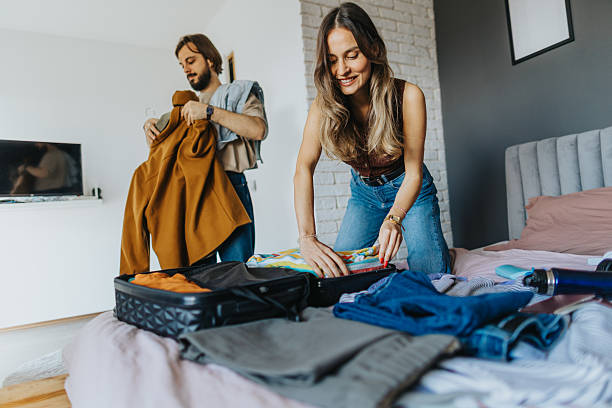 istock Happy young couple packing for a trip 2209683566