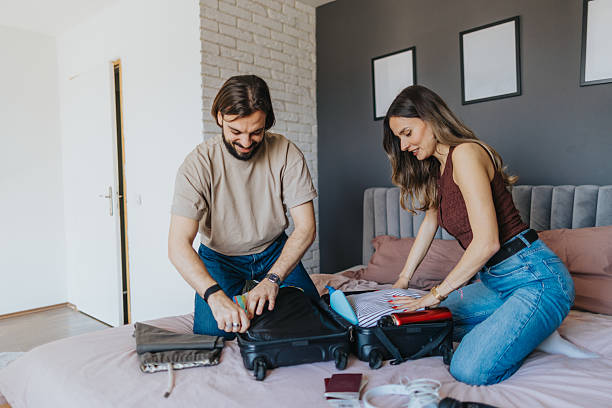 istock Happy young couple packing for a trip 2209684080