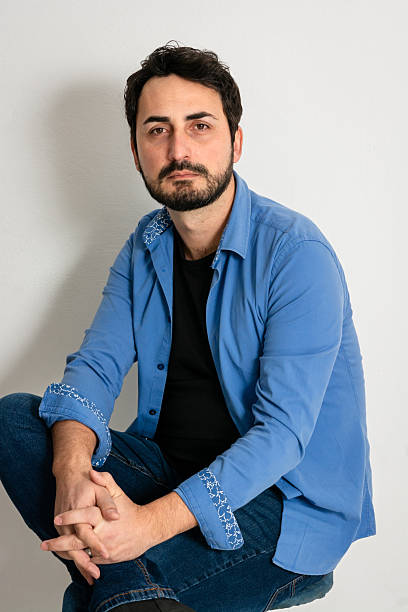 istock Man sitting on a chair against white background 2209684512