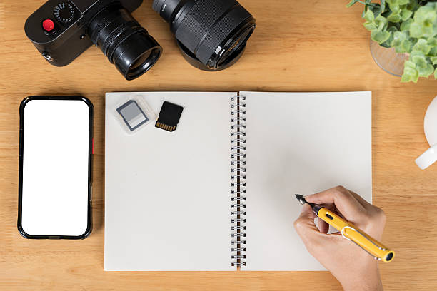 istock A person is writing on a tablet with a pen. a phone with a screen mockup, a coffee cup of writing supplies. 2209684656