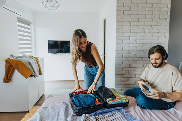 istock Cheerful young couple at home preparing for vacation 2209684724
