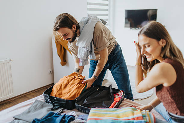 istock Happy young couple packing for a trip 2209685309