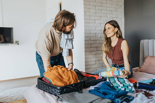 istock Happy young couple packing for a trip 2209685345