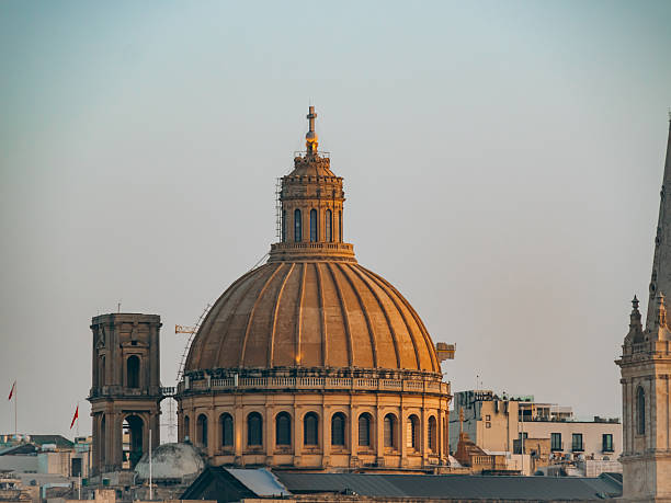 Low angle view on Dome of Basilica, in front purple flowers, Valetta, Malta