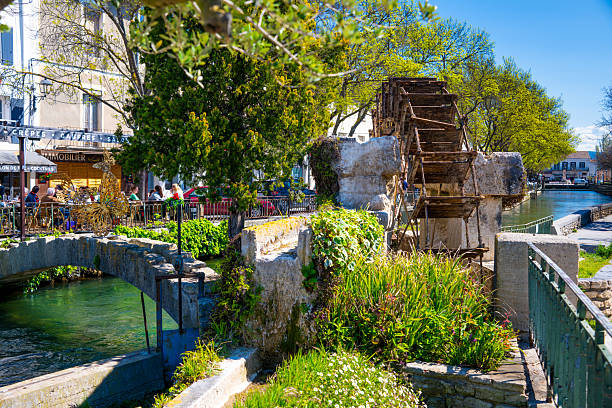 Beautiful French village of Isle sur la Sorgue - People having lunch along the Canals and watermill