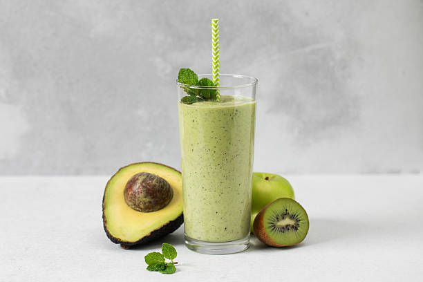 istock Refreshing green smoothie with avocado and kiwi on grey background. Detox 2209687241