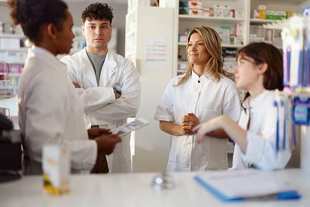 istock Team of pharmacists talking in a drug store. 2209687938