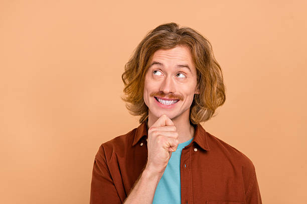istock Portrait of attractive cheerful minded red-haired guy thinking copy blank space isolated over beige pastel color background 2209689585