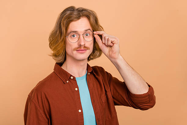 istock Portrait of attractive intelligent content skilled red-haired guy touching specs isolate over beige pastel color background 2209689610