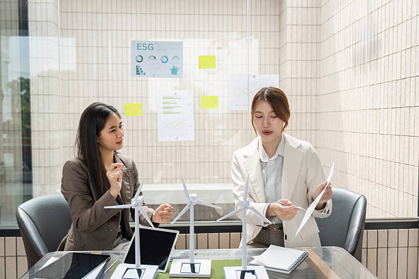 istock ESG and Sustainable Development. Two professionals discuss renewable energy solutions in a modern office setting. 2209692024