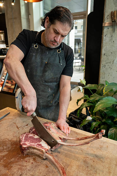 istock Butcher slices raw beef roast in shop 2209694103