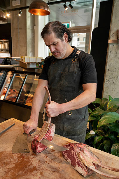 Butcher slices raw beef roast in shop