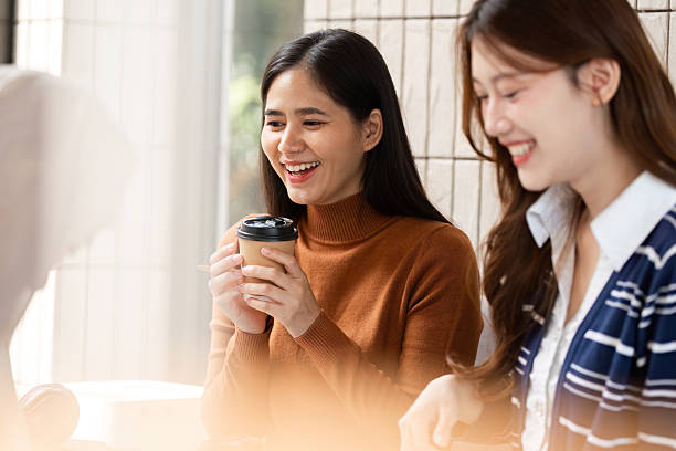 istock Coffee Break and Socializing. A joyful student enjoying a coffee break with friends in a bright cafe. 2209694139