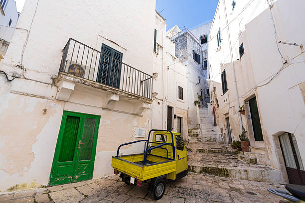Piaggio Ape truck in the narrow street of the white medieval village of Ostuni, summer scene, Brindisi province, Apulia, Italy, Europe