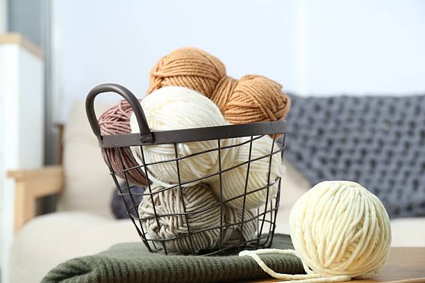 istock Basket with yarns and sweater on table indoors 2209695973