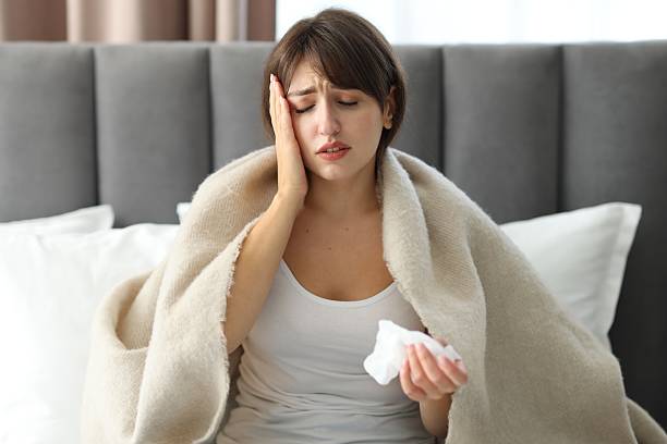 istock Woman wrapped in blanket suffering from sinusitis on bed 2209698040