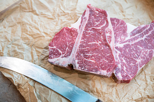 Raw beef steaks on paper in gourmet butcher shop, Vancouver, B.C.
