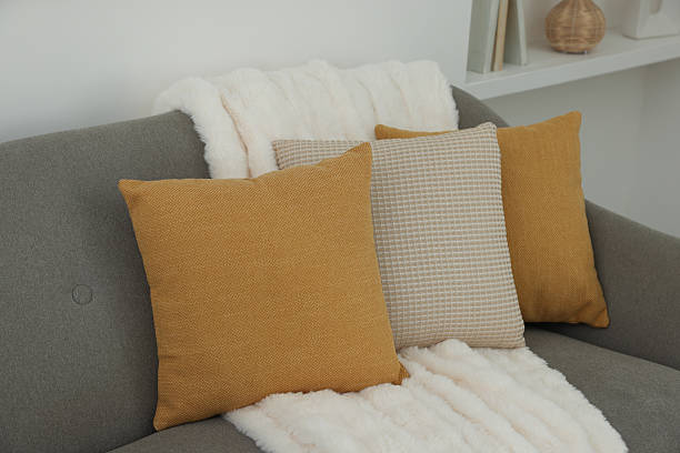 istock Different soft pillows and blanket on sofa in room 2209698703