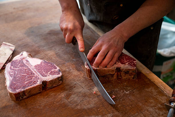 istock Butcher slices raw beef steaks by hand 2209699501