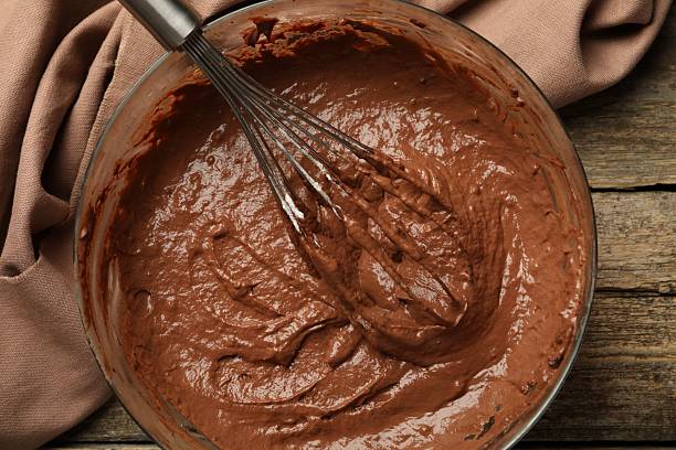 istock Chocolate dough in bowl and whisk on wooden table, top view 2209699727