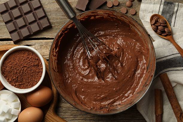 istock Chocolate dough in bowl among ingredients on wooden table, flat lay 2209699827