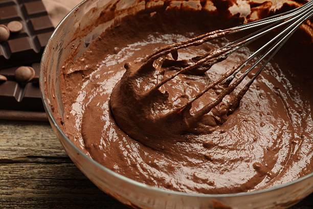 istock Chocolate dough in bowl and whisk on wooden table, closeup 2209699832