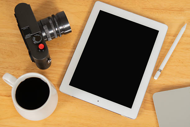 Camera, cup of coffee ,pen and notepad on wooden background, Travel Planner concept. Top view, copy space.