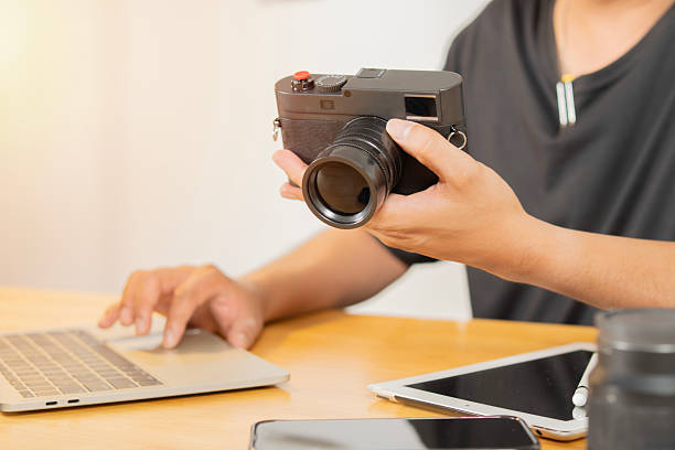 istock Young male photographer checking shots and editing photos on his computer while working 2209700767