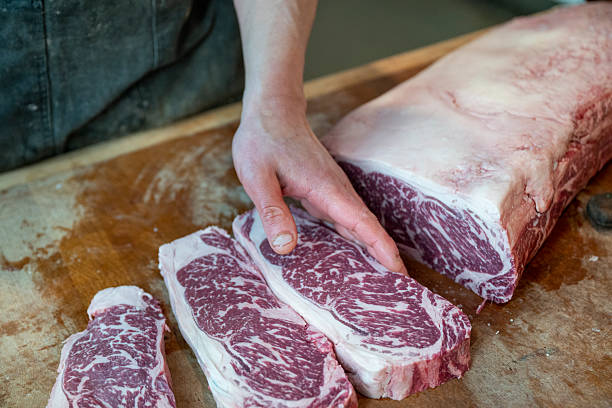 istock Butcher holds raw beef steaks in shop 2209701072