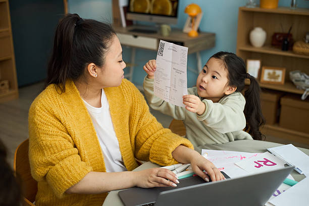 istock Mother Helping Child with Schoolwork at Home 2209701568