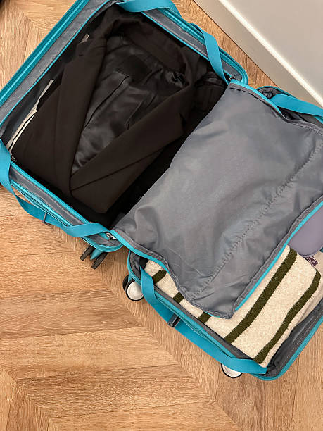 istock Open suitcase from above with personal accessories and clothes. 2209701937