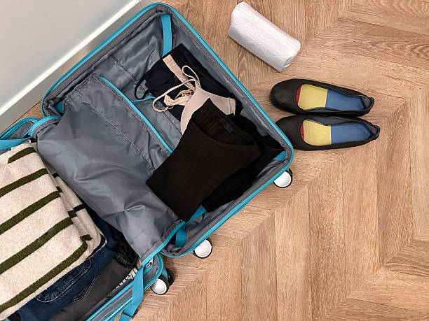 istock Packing at home: open suitcase with clothes ready for travel. 2209702067