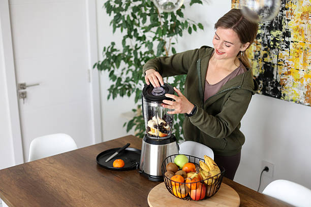 istock Young woman making a smoothie 2209703541