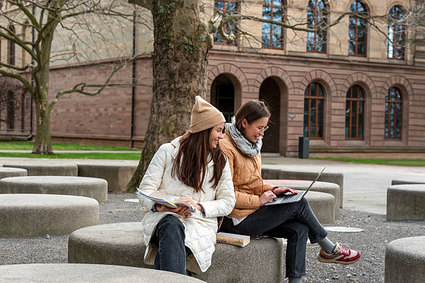 istock Young women studying in a serene autumn campus park 2209703565