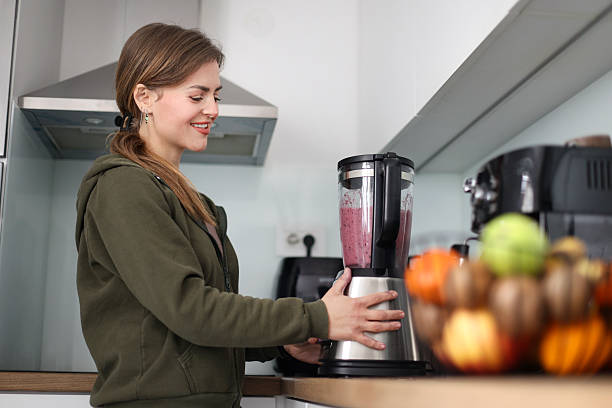 istock Young woman making a smoothie 2209703672