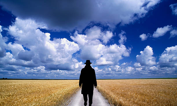 istock Prairie wheat field man walking on road. 2209704121