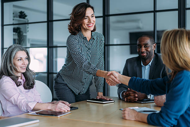 istock Businesspeople shaking hands across the table. 2209704544