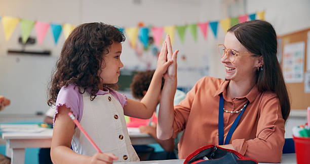 istock Education, teacher and high five student in classroom for lesson support, writing activity and learning progress. People, educator and girl with fine motor skills celebration or knowledge development 2209704668