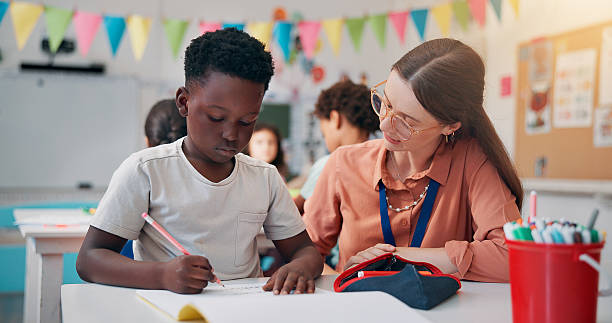 istock Education, boy or teacher in classroom, help or advice with literacy knowledge. Child development, woman or students in school, assisted learning or conversation with assessment, questions or support 2209704691