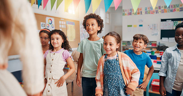 istock Teacher, education and lesson with students in classroom for child development, future and learning. Academy, growth and scholarship with group of kids in school for knowledge, youth and study 2209704751