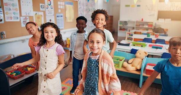 istock Portrait, education and youth with students in classroom for child development, future and learning. Academy, growth and scholarship with group of kids in school for knowledge, lesson and study 2209704774
