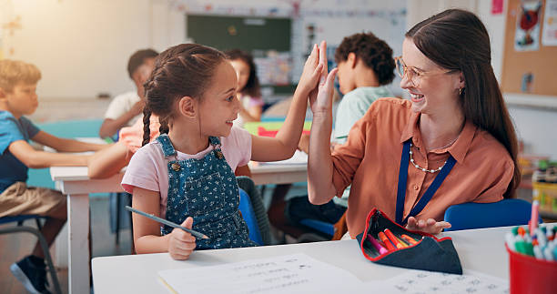 istock Education, teacher and high five girl in classroom for lesson support, creative activity and learning progress. People, educator and student with fine motor skills success and knowledge development 2209704779