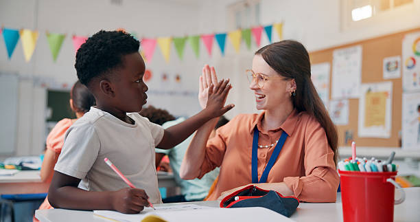 istock Education, teacher and high five boy in classroom for lesson support, creative activity and learning progress. People, educator and student with fine motor skills achievement or knowledge development 2209704836