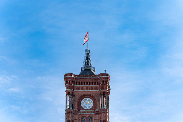istock A clock tower with a red and white flag on top 2209708174