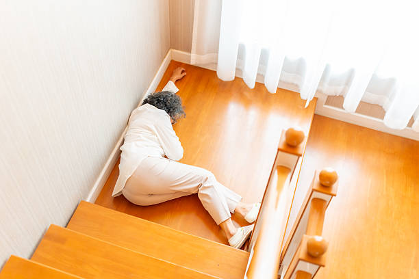 Emergency medical healthcare services, injury and health insurance in elderly people. Unconscious Asian senior woman fell down the stairs suffering from heart attack, stroke symptoms in nursing home.