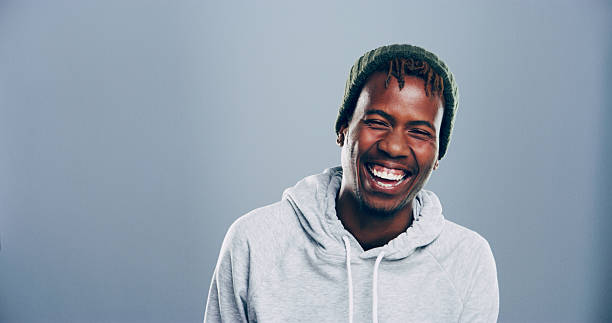 istock Happy, black man and laughing in studio for funny joke, comedy or goofy with mockup space. Face, portrait and African person with humor, excited and lol with comic emotion isolated on gray background 2209713455