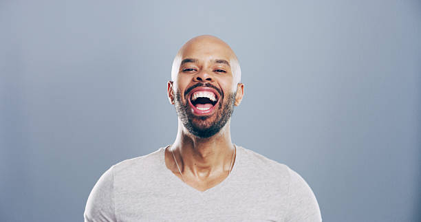 istock Comedy, man and portrait for laugh in studio with confidence, joke or good mood on gray background. Space, excited model and smile with carefree personality for comic, humor or funny reaction to meme 2209713549
